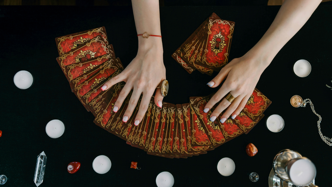 Hands Spreading Tarot Cards With Candles