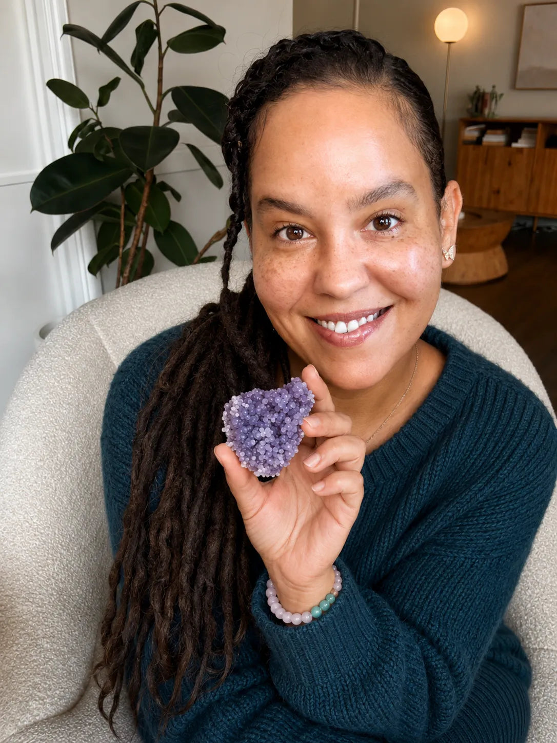 Dahlia smiling and holding up a Grape Agate cluster