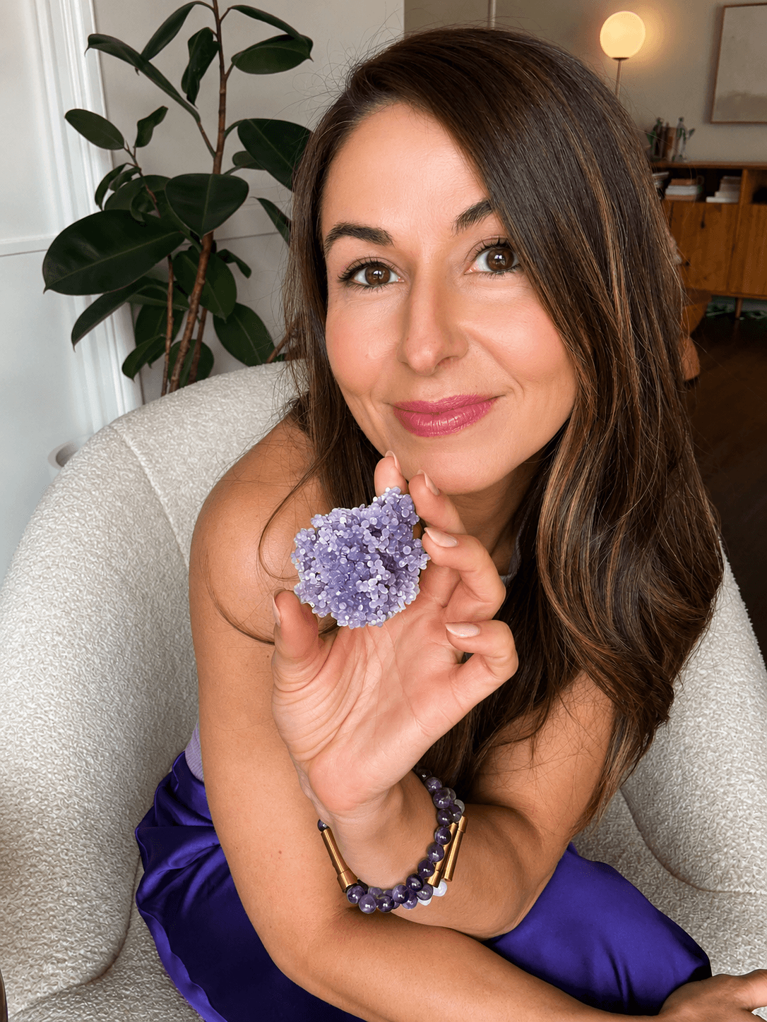 Mia smiling and holding a Grape Agate cluster